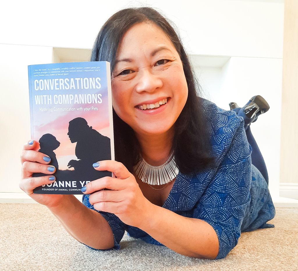 Joanne smiling holding her book Conversations with Companions